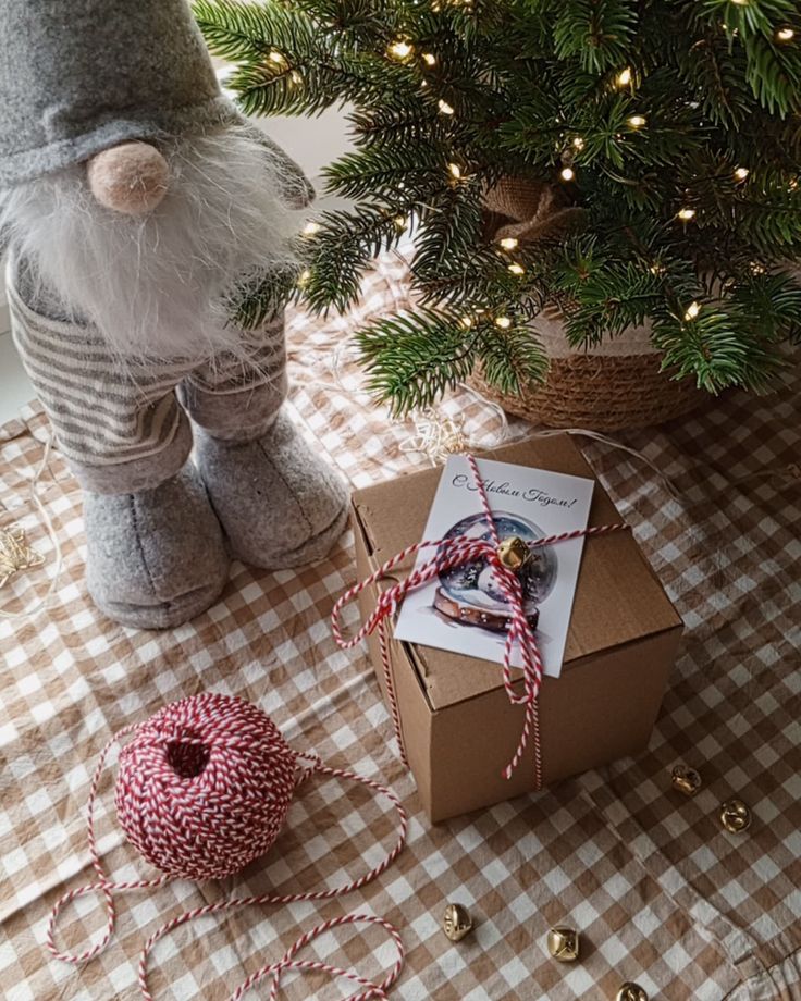 Упаковка моих свечей ручной работы это не просто Festive scene with gnome figurine, gift box, and Christmas tree on checkered tablecloth. | Sky Rye Design Festive scene with gnome figurine, gift box, and Christmas tree on checkered tablecloth.