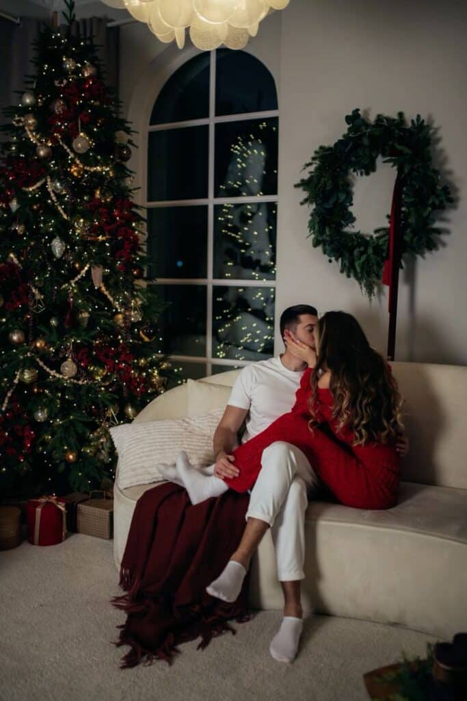 кЦЫум Couple embracing by Christmas tree, festive decorations, cozy holiday atmosphere. | Sky Rye Design Couple embracing by Christmas tree, festive decorations, cozy holiday atmosphere.
