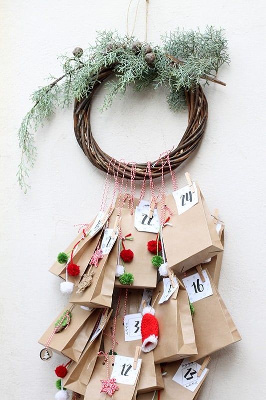 DIY Christmas wreath with brown paper advent calendar bags and festive decorations.