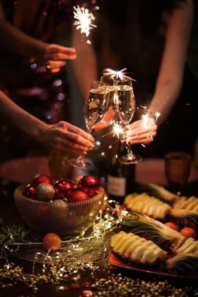 Celebratory toasting with sparklers and festive decorations at a holiday party.