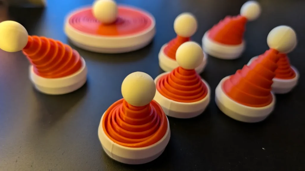 Red and white conical game pieces on a dark surface, resembling festive hats with white spheres on top.