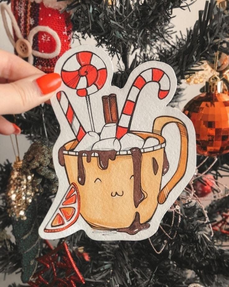 Cute hot chocolate mug illustration with marshmallows and candy canes, held near a decorated Christmas tree.