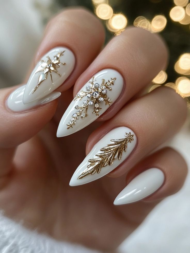 Elegant white and gold holiday nail art featuring snowflakes and pine designs with sparkling embellishments.