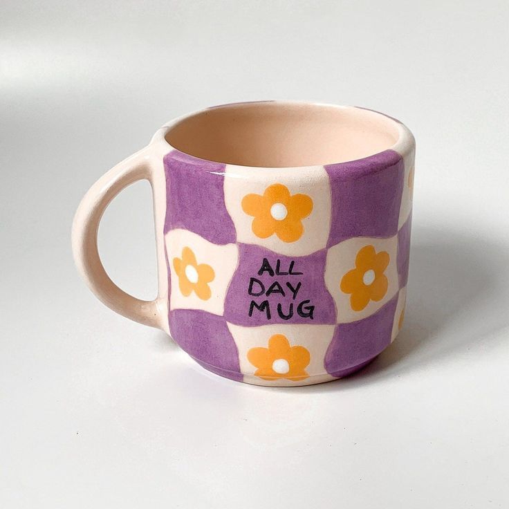 Colorful ceramic mug with purple and orange floral design and All Day Mug text, perfect for everyday use.