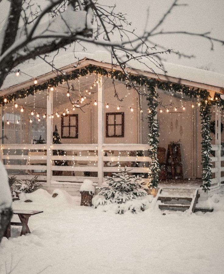 Cozy snow-covered cabin decorated with festive lights and garland, set in a serene winter landscape.