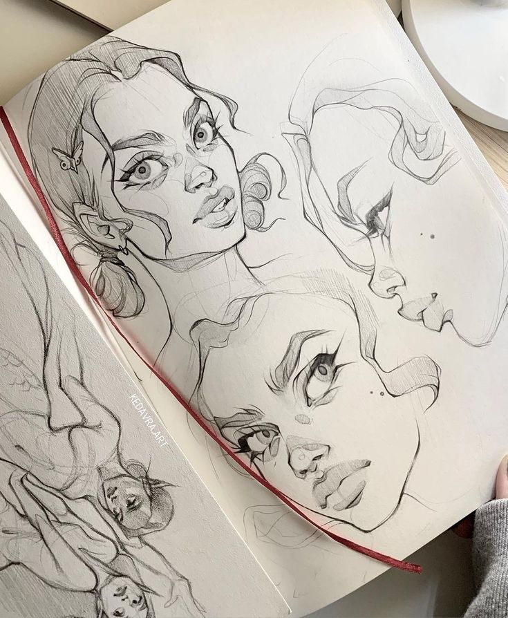 Sketchbook page with detailed pencil drawings of expressive female faces and figures, featuring intricate shading and lines.