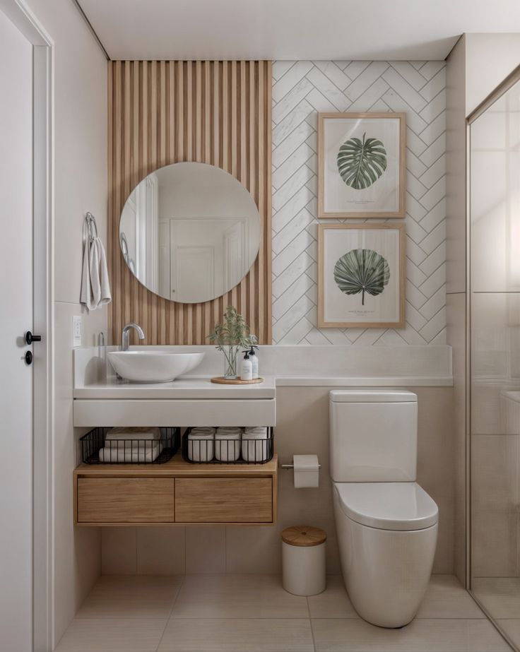 Modern bathroom with wooden accents, wall art, round mirror, and white fixtures for a sleek, minimalist design.