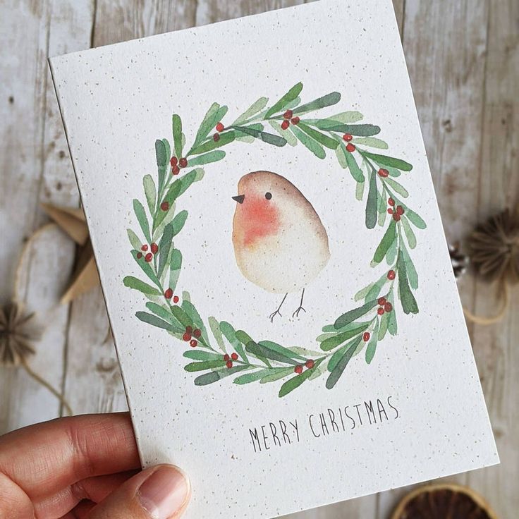 Handmade Christmas card with a watercolor robin and festive wreath design.