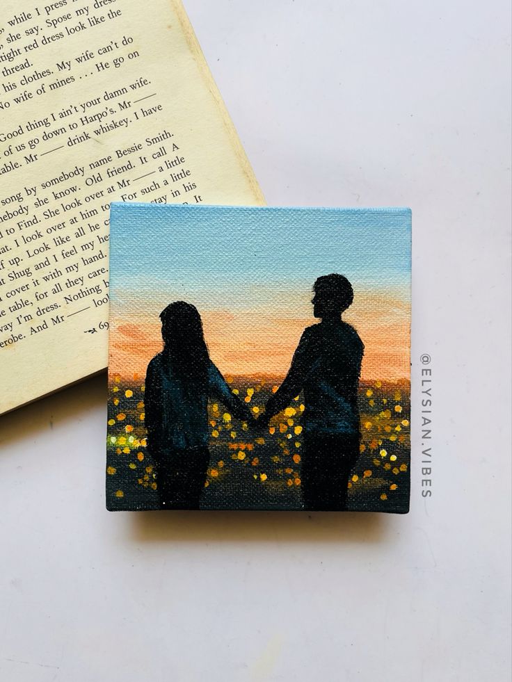 Silhouette couple holding hands at sunset, impressionist painting on canvas, next to an open book page.