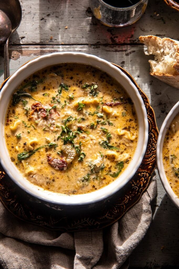 Creamy chicken and herb soup in a rustic bowl with bread on a wooden table. Perfect for cozy winter dining.