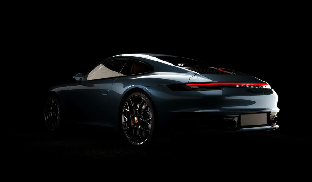 Sleek blue sports car with modern styling and elegant curves in a dimly lit studio setting.