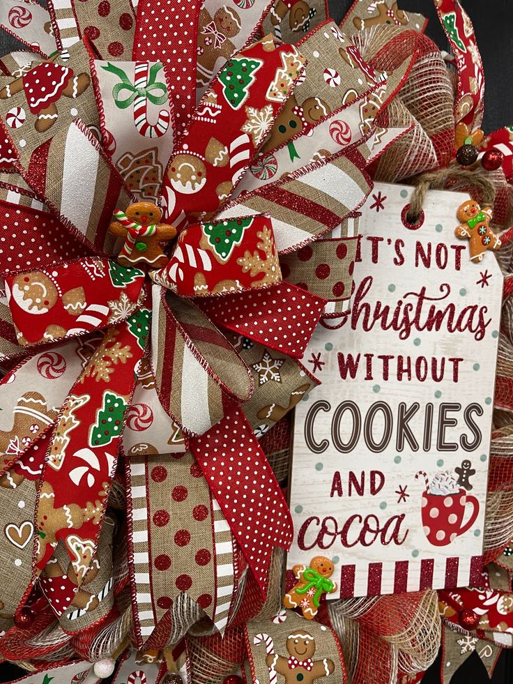 Festive Christmas wreath with red ribbons, gingerbread cookies, and a sign reading It's Not Christmas Without Cookies And Cocoa.