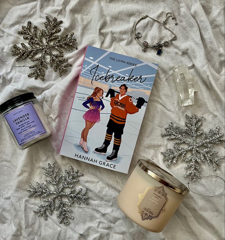 Book Icebreaker with hockey theme surrounded by candles, snowflakes, and a bracelet on a cozy setting.