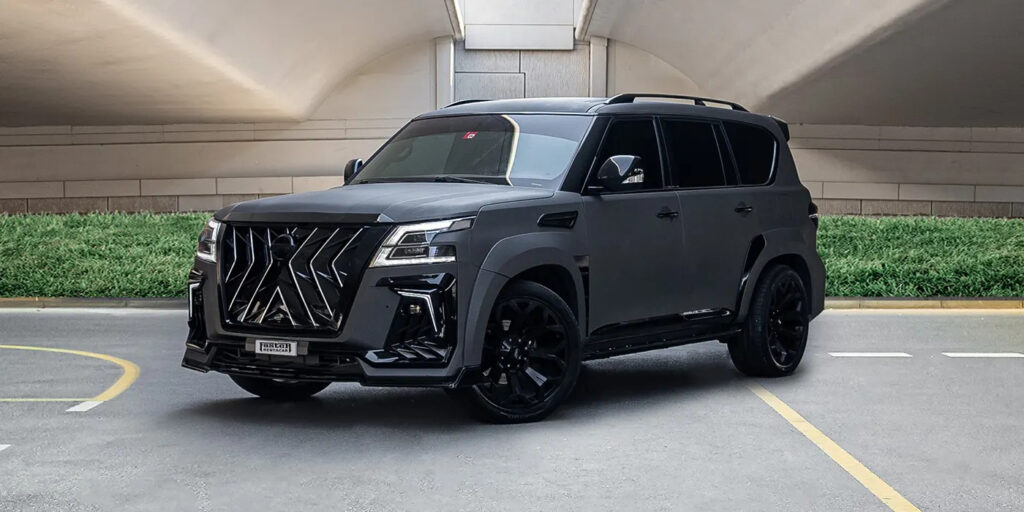 Sleek black luxury SUV parked under a modern bridge, showcasing a bold front grille design.