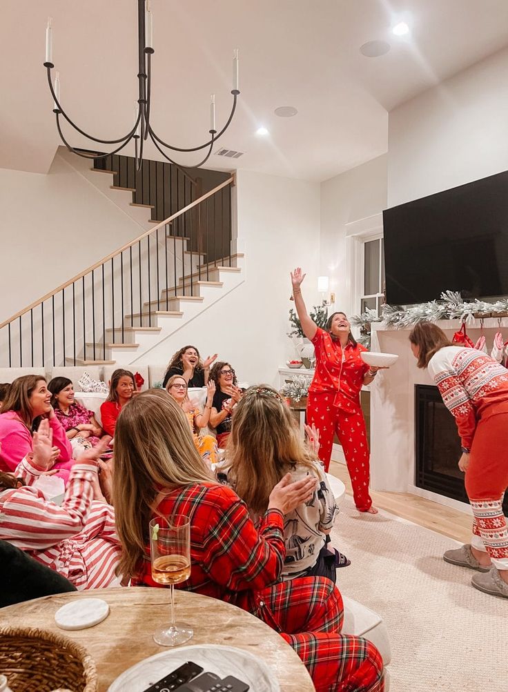 Group of women in festive pajamas enjoying a lively holiday party at home with laughter and joy.