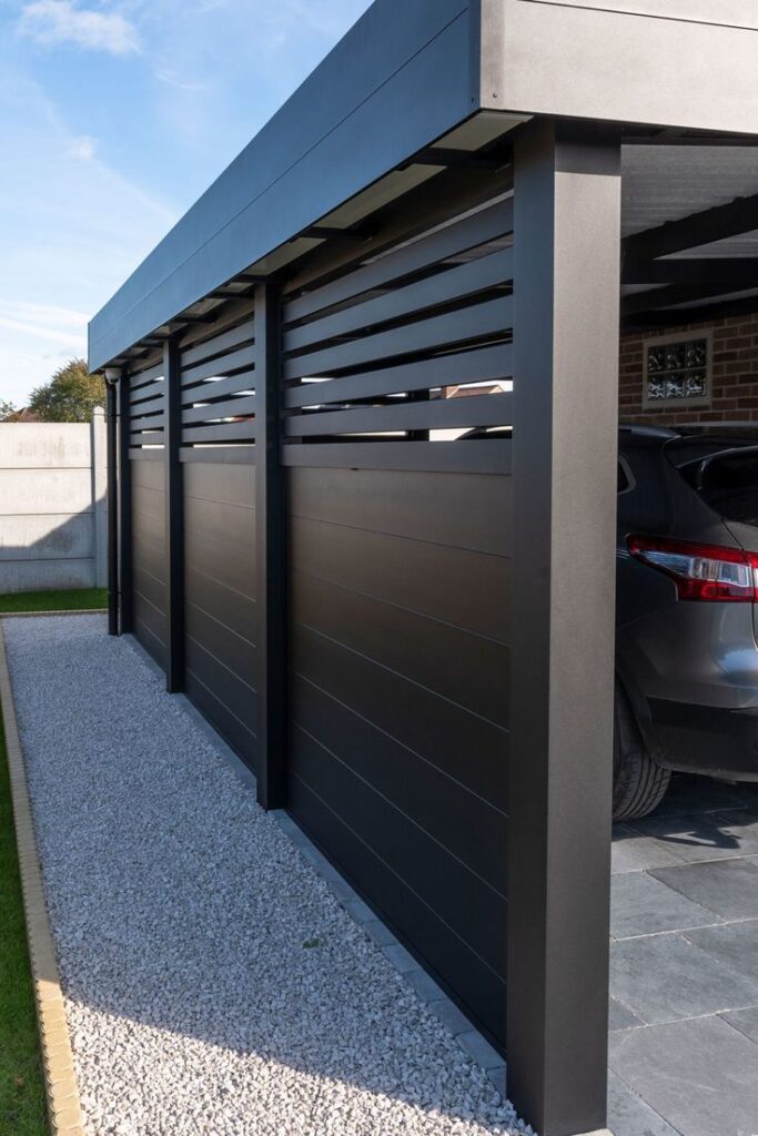 Modern black carport with sleek design and gravel pathway, adjacent to a parked car. Ideal for home exterior upgrades.