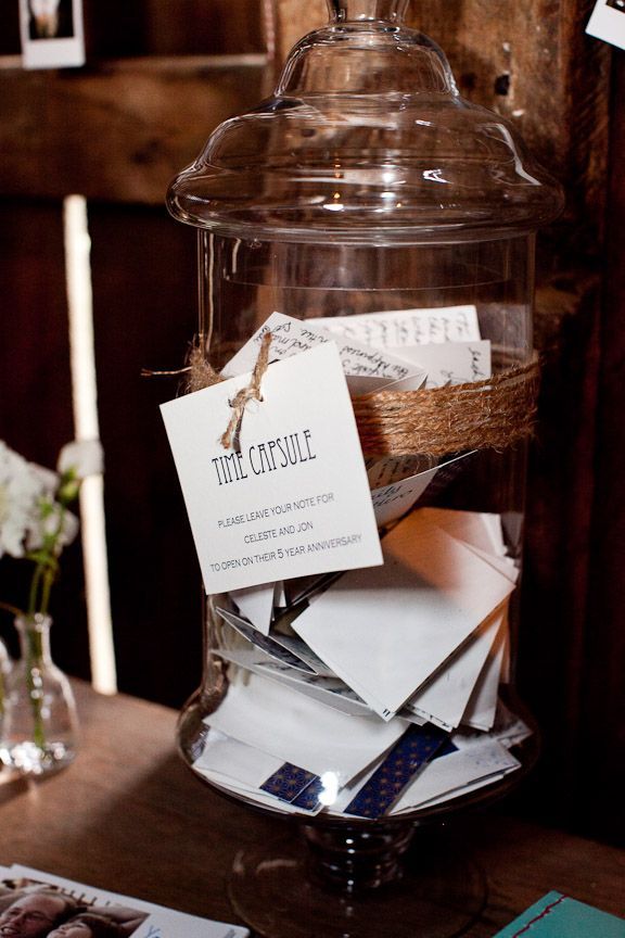 Glass jar time capsule filled with notes and letters, labeled for a couple's 5th anniversary celebration.