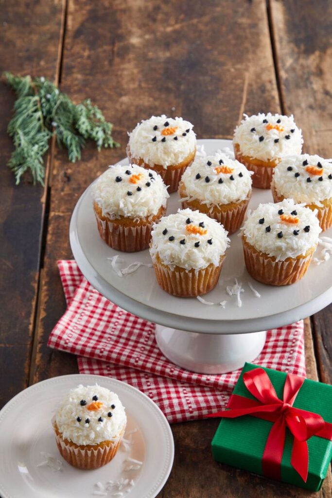 Festive snowman cupcakes on a rustic table, perfect for holiday celebrations and winter treats.