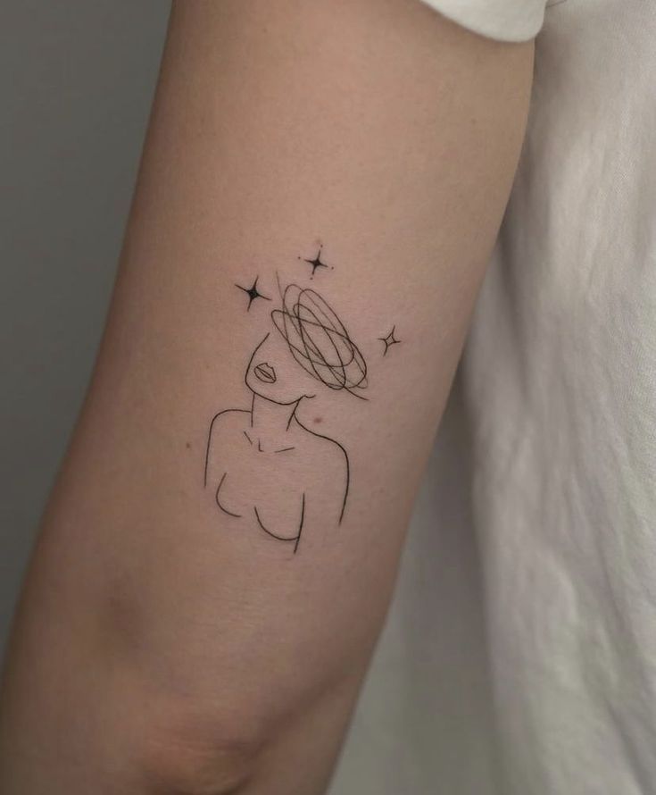 Minimalist tattoo of a female figure with stars and scribbles on the arm.