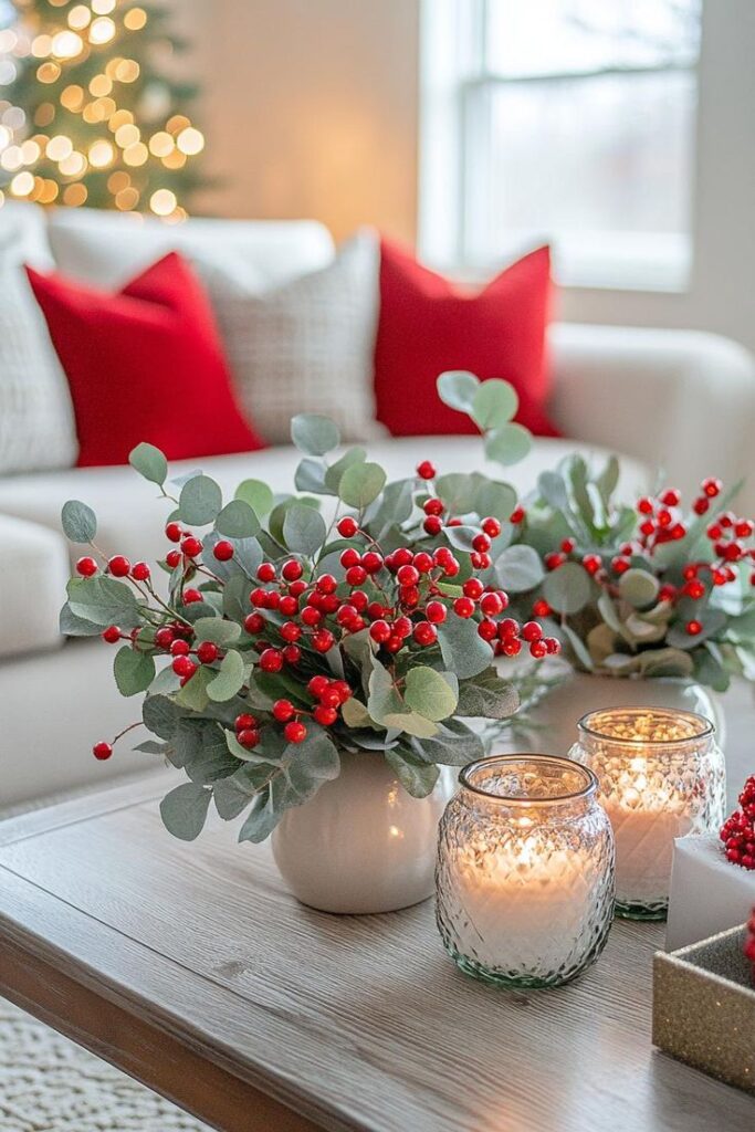 Festive living room decor with red berries, candles, and cozy pillows on a white sofa. Holiday ambiance and warmth.