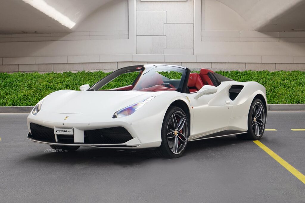 White convertible sports car with red interior parked under a bridge.