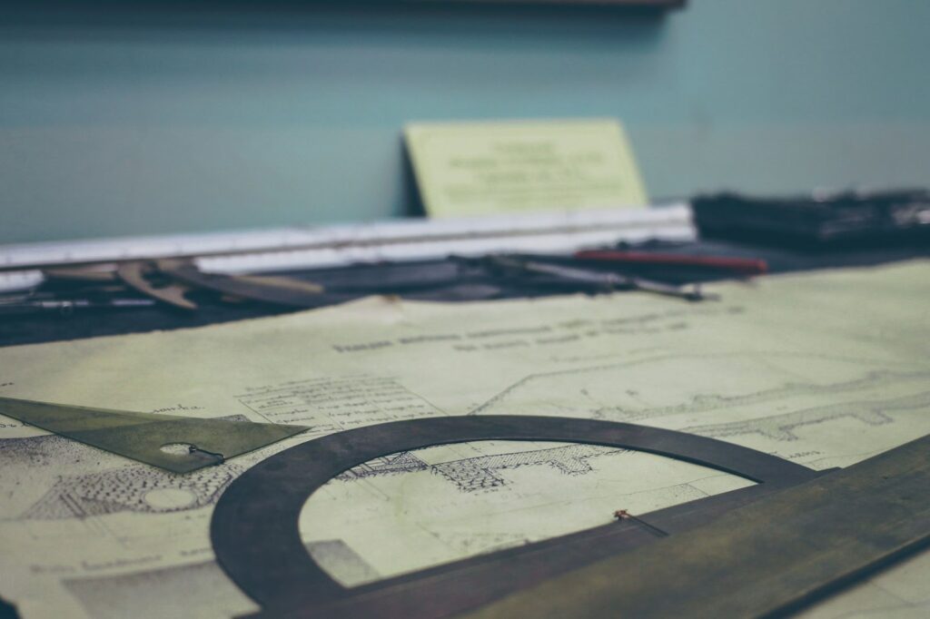 Vintage drafting tools and architectural blueprints on a desk, evoking classic engineering and design.