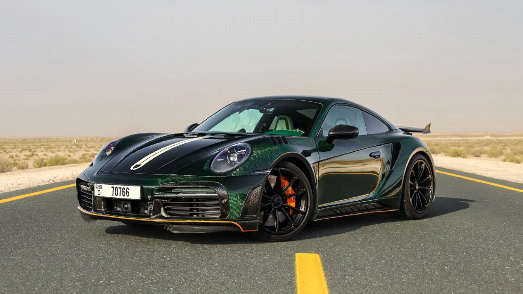 Sleek black sports car on deserted highway under clear sky, front view highlighting design and performance.