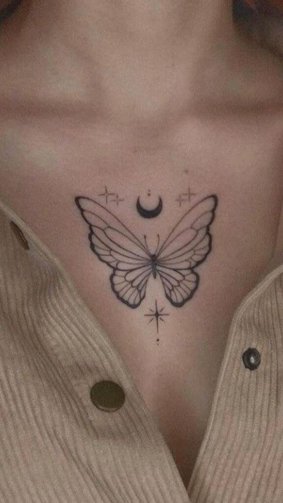 Elegant butterfly tattoo with crescent moon and star designs on chest, framed by beige striped fabric.