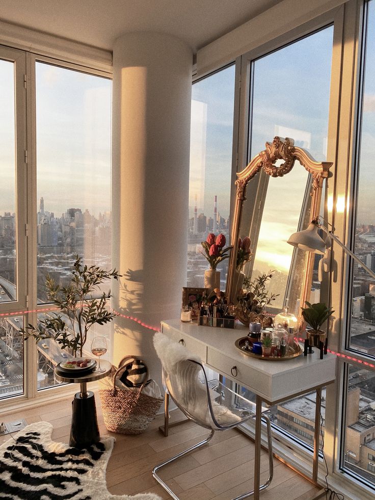 Luxurious city-view vanity space with elegant decor and large windows at sunset.