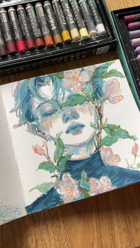 Artistic portrait with flowers covering the face, surrounded by pastel colors and oil pastels on the side.