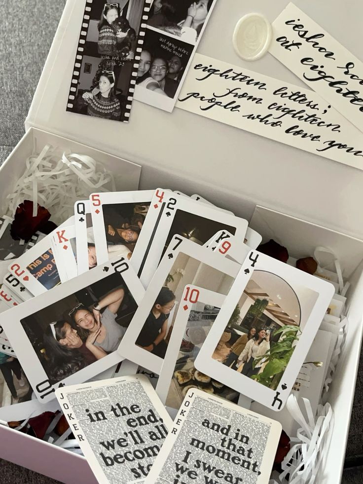 Box filled with playing cards featuring photos, handwritten notes, and film strips for a sentimental gift.