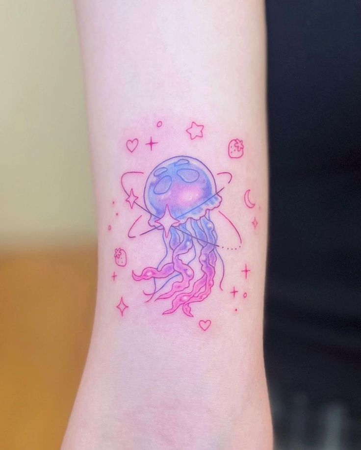 Colorful jellyfish tattoo with cosmic elements and stars on forearm.