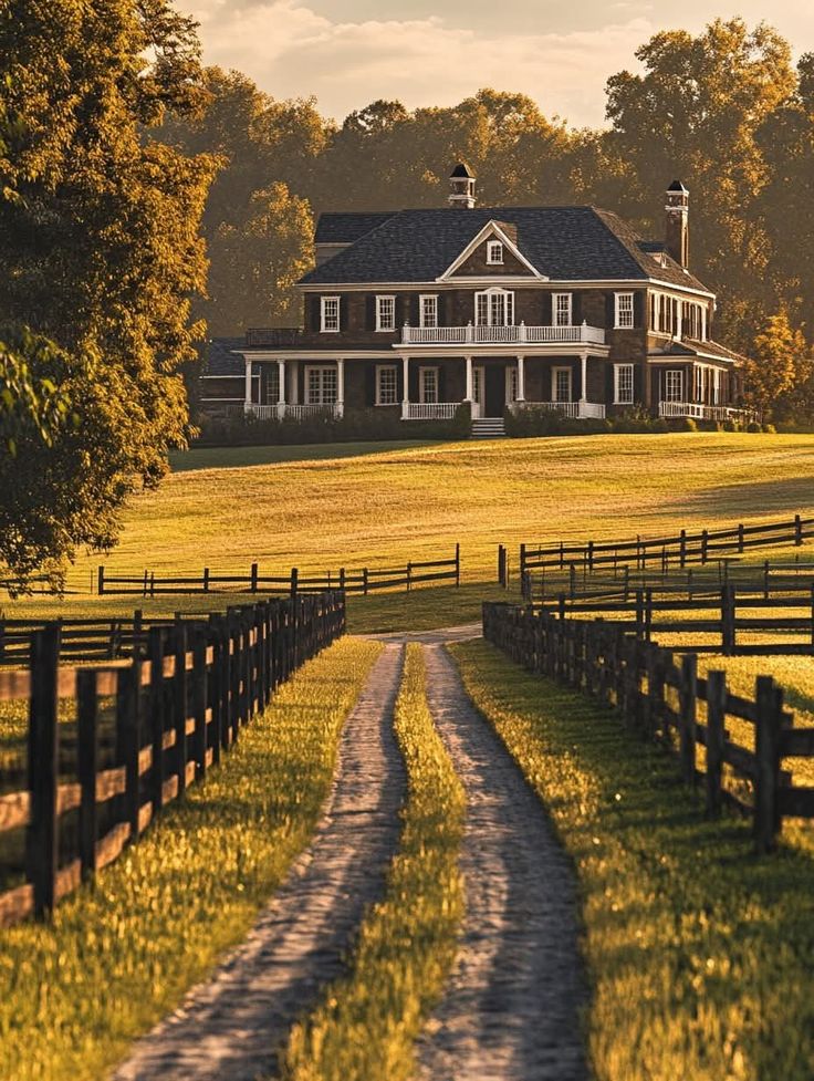 Country house with a long dirt road and fences, surrounded by trees under a golden sunset. Perfect rural retreat setting.