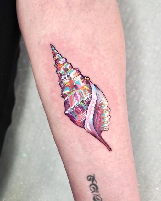 Vibrant conch shell tattoo on forearm with multicolored details, showcasing intricate 3D art design.