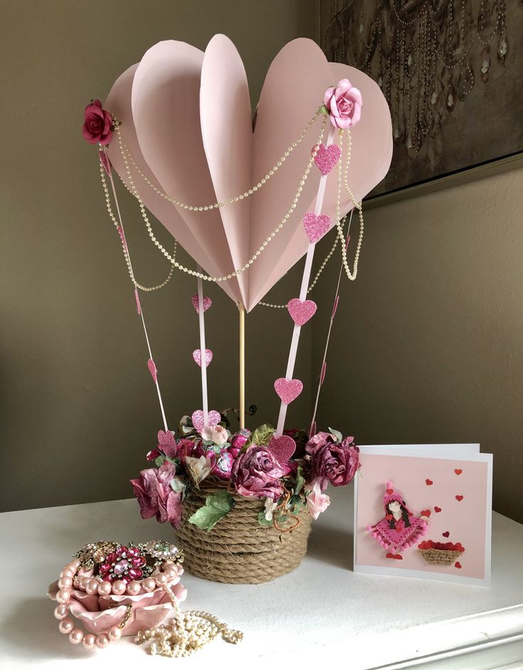 Romantic heart-shaped paper decor with pearls and flowers, perfect for Valentine's or a wedding centerpiece.