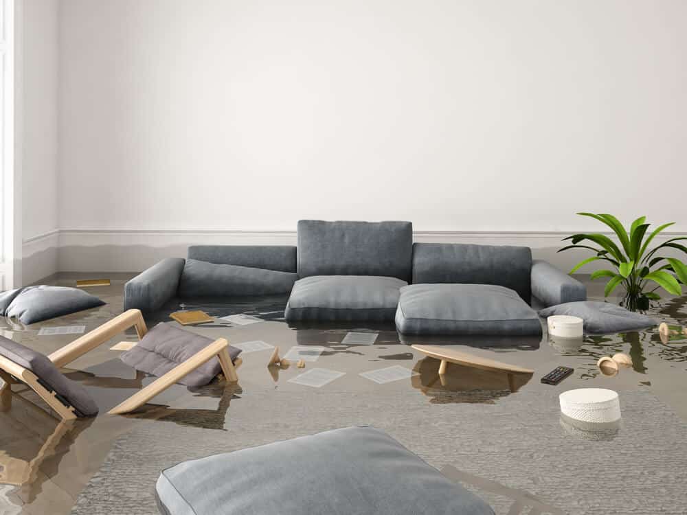 Flooded living room with floating furniture and scattered items, highlighting damage and chaos.