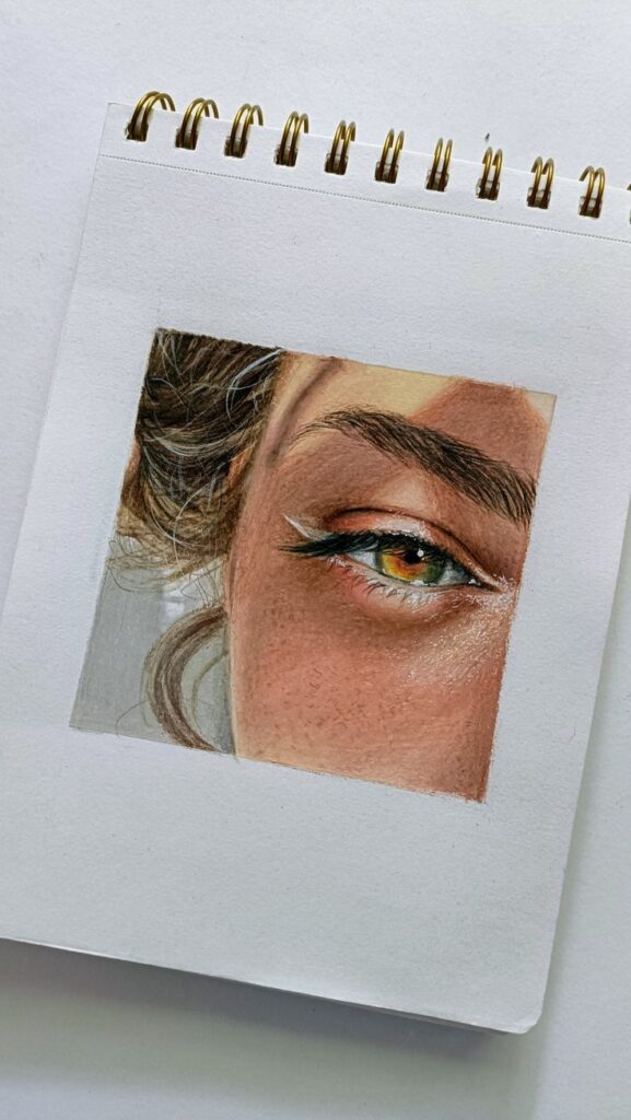 Close-up drawing of an eye with intricate detail on a sketchbook page, showcasing realistic art techniques.