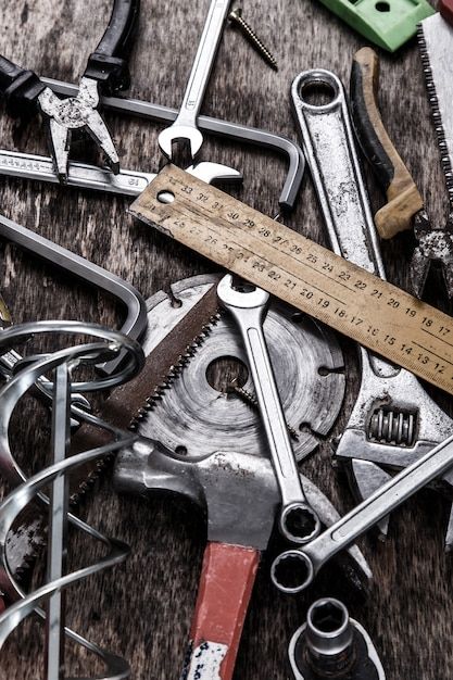 Assorted tools on a wooden surface, including wrenches, hammer, ruler, and saw blade. Ideal for DIY or workshop themes.