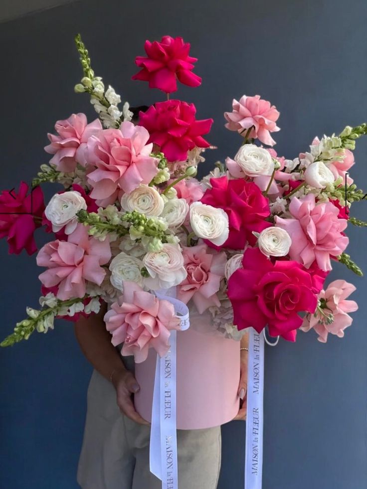 Elegant pink and white floral arrangement with roses and assorted flowers in a large bouquet against a dark background.