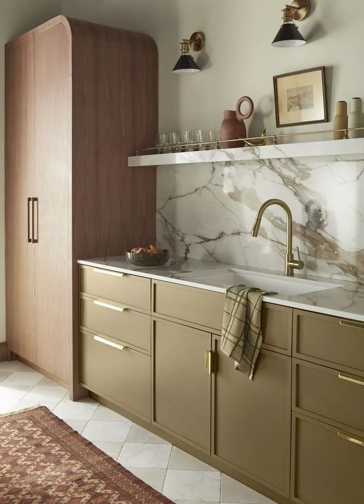 Modern kitchen with marble backsplash, brass fixtures, and wooden cabinets. Elegant decor with warm lighting and neutral tones.