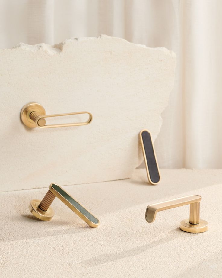 Elegant gold door handles displayed on a minimalist background, featuring modern design and sleek finishes.