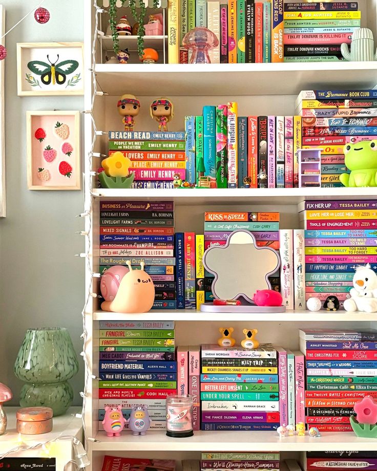 Colorful bookshelf with vibrant books, cute figurines, and decorative lights in a cozy reading nook.