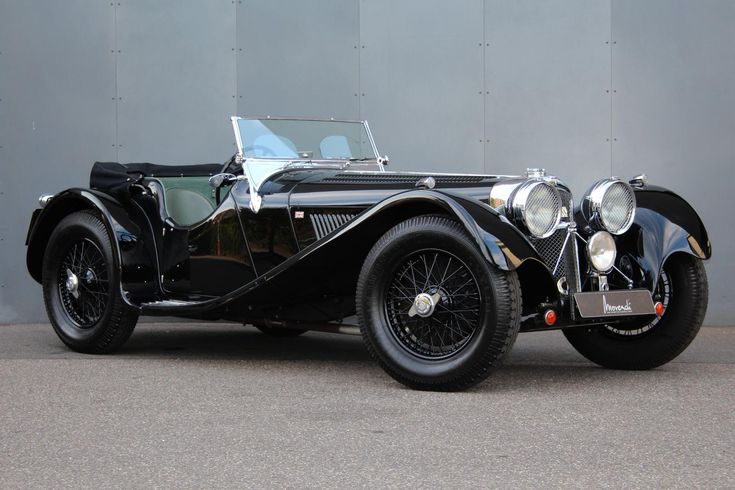 Classic black vintage convertible car with chrome details, displayed on a neutral background.