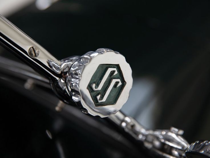 Close-up of vintage car wiper lever with hexagon logo details on chrome cap.