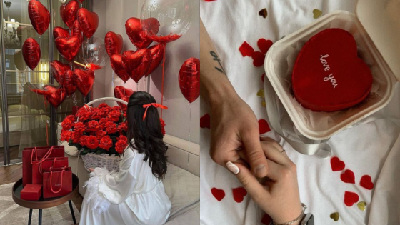 Romantic setting with red balloons, roses, gifts, a heart-shaped cake, and couple holding hands.