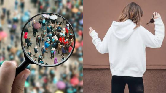 Magnifying glass zooms in on crowded street; woman in hoodie holding sunglasses with her back turned.