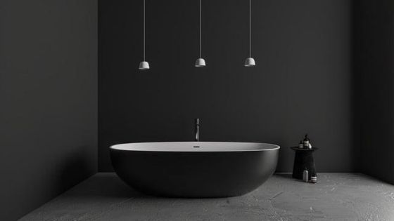 Minimalist bathroom with a sleek black freestanding bathtub, grey walls, and modern hanging lights. Ideal for luxury interiors.