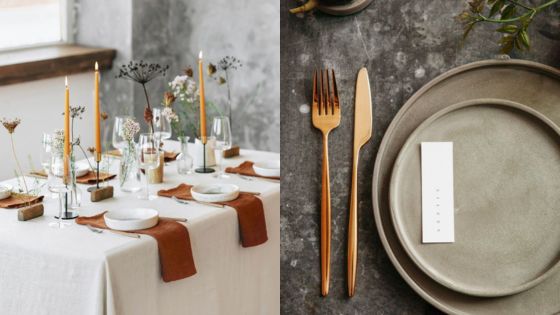 Elegant dining table setting with candles, rustic decor, and minimalist dinnerware on a textured surface.