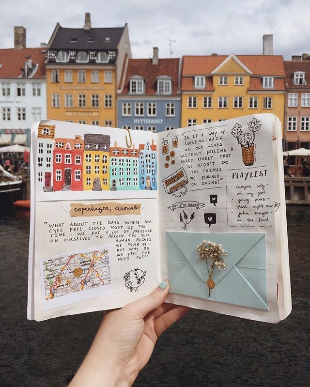 Open journal featuring Copenhagen illustrations and notes against colorful waterfront houses.