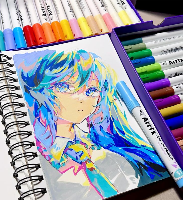 Colorful anime-style drawing in sketchbook with Artix markers, showcasing vibrant blue hair and artistic flair.